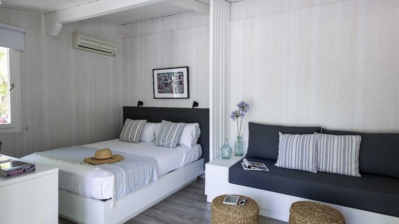 Tr�ningsresor, Ljust rum p� Tamarit Beach Resort med dubbels�ng, sittb�nk och modern inredning.